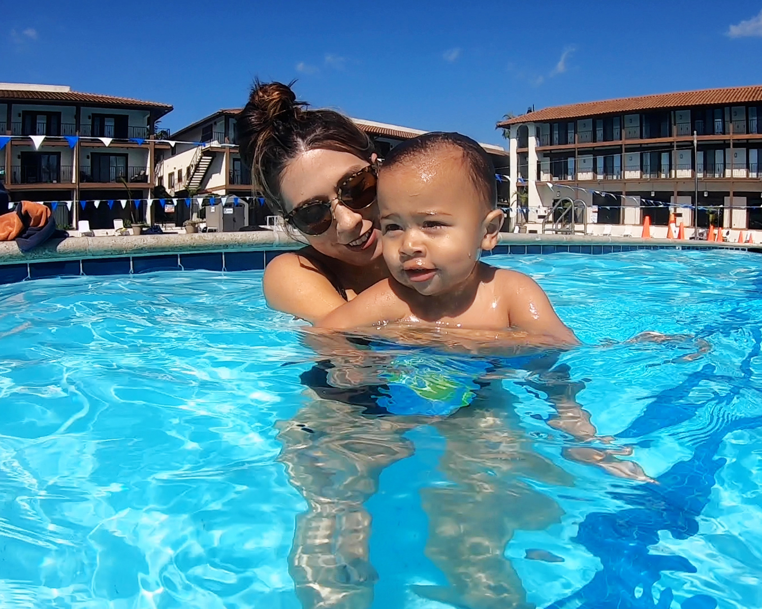 parent tot Parent holding a toddler in the pool during a swim lesson at Los Caballeros Sports Club
